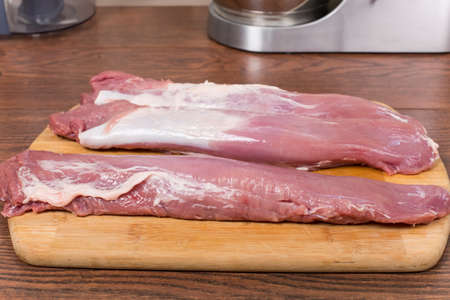 raw pork tenderloin on a cutting Boardの写真素材