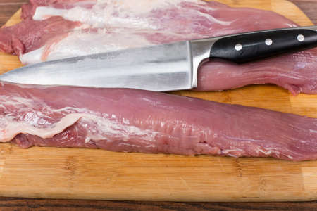 raw pork tenderloin on a cutting Boardの写真素材