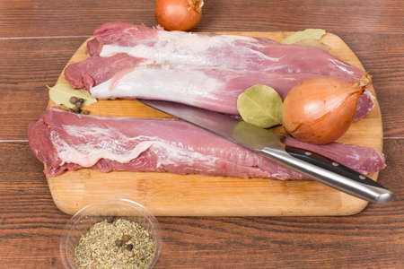 raw pork tenderloin on a cutting Boardの写真素材