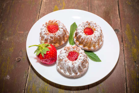 strawberry cupcakes on an old wooden tableの写真素材
