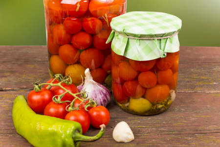 Canned red cherry tomatoes in glass jarsの写真素材