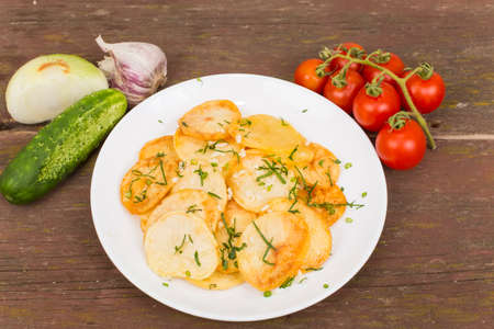 fried potatoes at home plate on an old wooden tableの写真素材