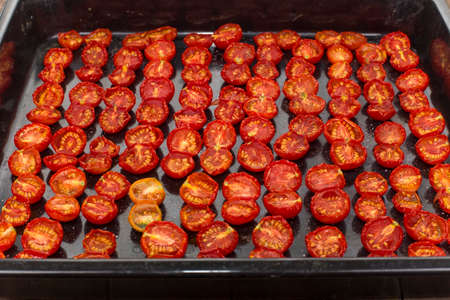 sun-dried tomato halves spread out on the baking sheetの写真素材