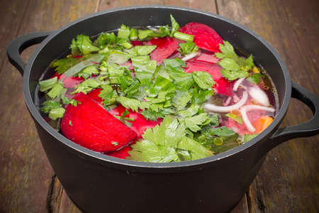 fish with vegetables folded into the cauldron and filled with waterの写真素材
