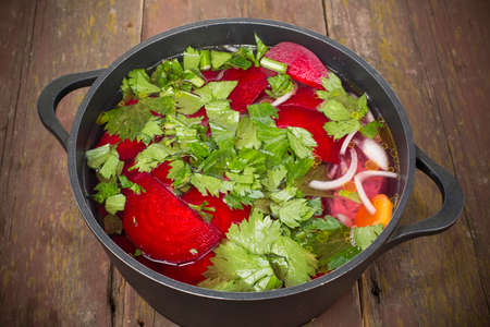 fish with vegetables folded into the cauldron and filled with waterの写真素材