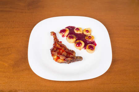 Fried chicken leg with raspberry sauce and fried bananasの写真素材