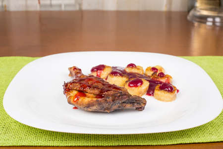 Fried chicken leg with raspberry sauce and fried bananasの写真素材