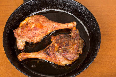 Roasted duck legs on a cast iron skilletの写真素材