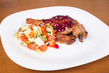whole leg roasted duck with raspberry sauce and saladの写真素材