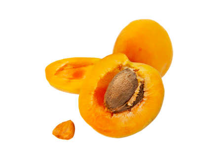 ripe large yellow apricot with half and stone isolated on white backgroundの写真素材