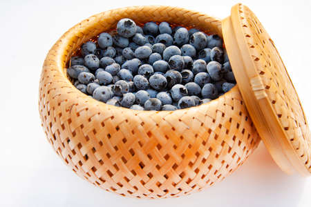 blueberries in a wicker basket close-up on a light backgroundの写真素材
