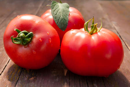 ripe red tomatoes close-up on an old wooden tableの写真素材