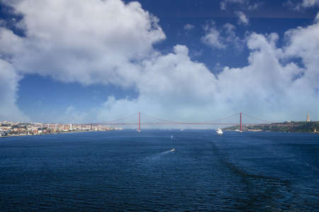 A ship Sailing through the 25th of april bridge
