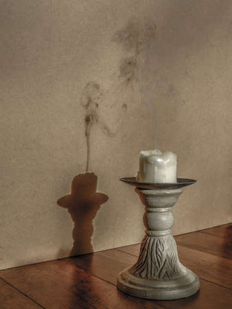 Extinguished candle with smoke and shadow on plain backgroundの写真素材