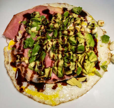 Baked egg with ham, goat cheese, avocado and balsamic oilの写真素材