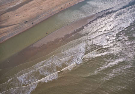 waves reaching the coast and breaking on sand bankの写真素材