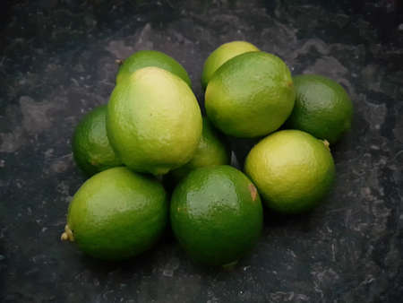 Limes in a black stone bowlの写真素材
