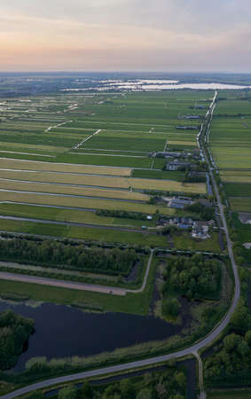 Aerial view of road leading through peat excavation meadow landscape in the netherlandsの写真素材