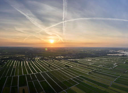Aerial panorama view of cultivated reclaimed land in the Netherlands at sunsetの写真素材
