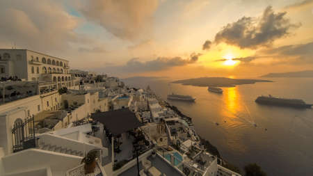 Panorama of Fira, Santorini with cruise ships during sunsetの写真素材