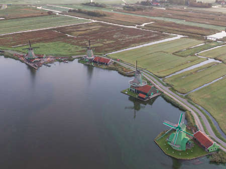 Aerial of classic dutch windmills at the Zaanse Schans with algae in the waterの写真素材