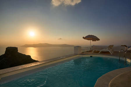 Sunset at a beautiful infinity pool in Santorini, Greeceの写真素材