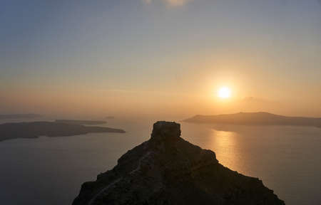 Beautiful sunset over rock formation on greek island Santorini in the mediterranean seaの写真素材