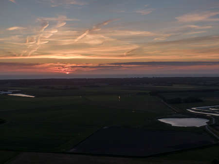 Aerial of sunset over agricultural meadowland and sea on the Dutch island of Texelの写真素材