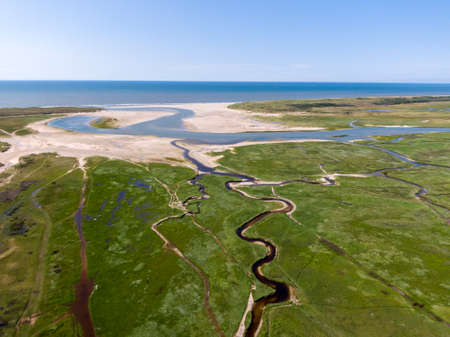 Aerial image of dutch national park with curving rivers in grassland towards the north sea on the...