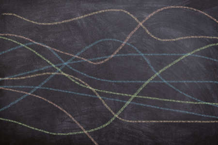 Abstract colorful wavy lines of crayons drawn by children on chalkboard, representing free hand drawing educational conceptの写真素材
