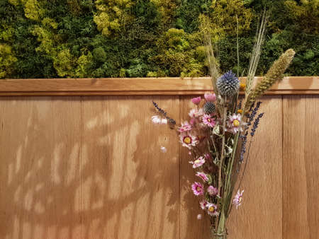Wooden wall with flowers background with copy space on the left for wishing card conceptの写真素材