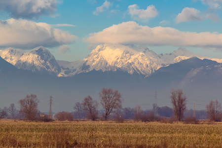 Rural view of the snowy mountains shrouded by clouds.の写真素材