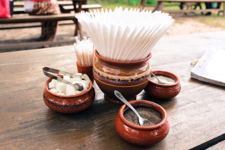 Condiments on a large wooden table in traditional clay pots.の写真素材