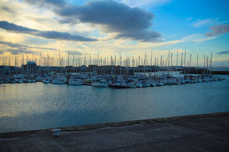 Evening bay at sunset with numerous moored sailboats.の写真素材