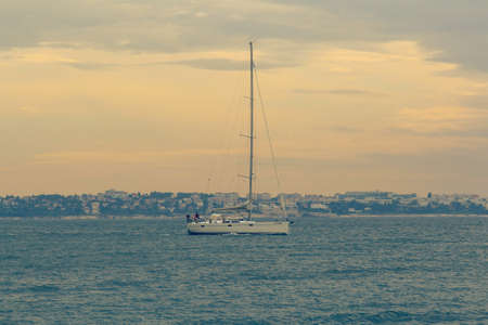 Sailboat leaves the bay to the open sea in the evening.の写真素材