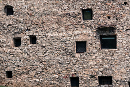Windows of various sizes and layouts in the medieval stone wall.の写真素材