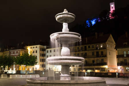 Ljubljana, Slovenia - June 23, 2015. Fountain in Novi trg city square at night on the background of Ljubljana castle.のeditorial素材