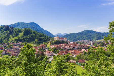 Skofja Loka, Slovenia - May 13, 2015. View of the Skofia Loka town and castle covered with greenery and mountains.のeditorial素材