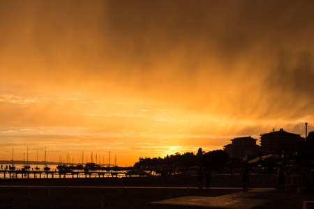 Bizzare sky and empty beach in the rays of the evening sun.の写真素材