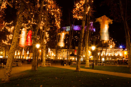 Ljubljana, Slovenia - November 27, 2015. Flying silhouettes hanging on trees at Kongresni square on the background of the castle.のeditorial素材