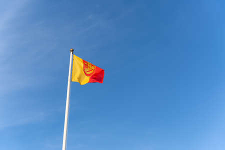 The flag of the Lithuanian port city of Klaipeda flies against the background of a blue clear cloudless skyの写真素材