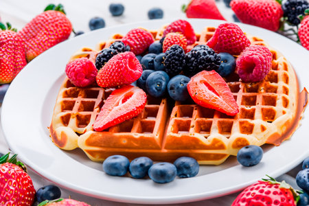 Berry Belgian Waffle with raspberries, strawberries and blueberries. Culinary, cooking, bakery, homemade concept. Food recipe background. Close up.の素材