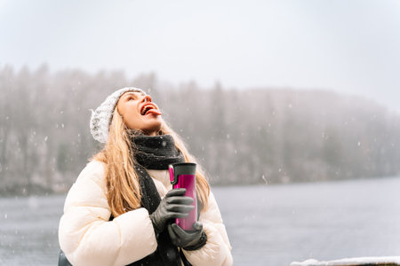 woman sticking out tongue playfully in snowy winter setting.