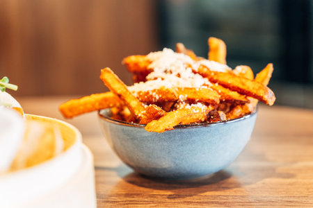 Crispy Sweet Potato Fries with Parmesan and Herbs in a Ceramic Bowl on a Wooden Table