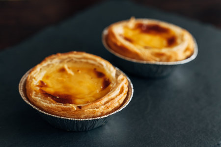 Freshly Baked Pastel de Nata on a Dark Rustic Background