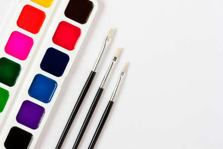 watercolor paint box and brushes on paper backgroundの写真素材