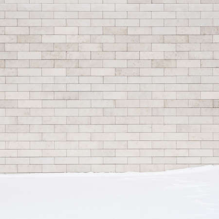 A white brick wall and a ground covered with snow. may use as a background.の写真素材