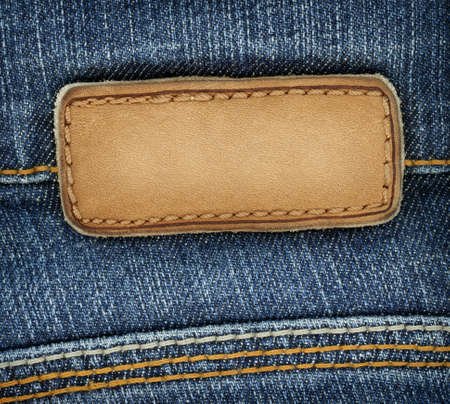 Blank leather jeans label sewed on a blue jeans. Can be used as background for your text.の写真素材