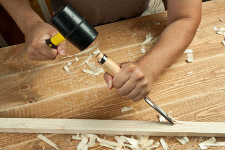 Wood workshop. Carpenter working with chisel.
