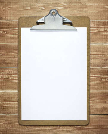 Clipboard with a blank sheet of paper on wooden table